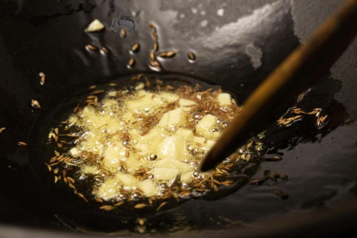 Add cumin seeds and garlic